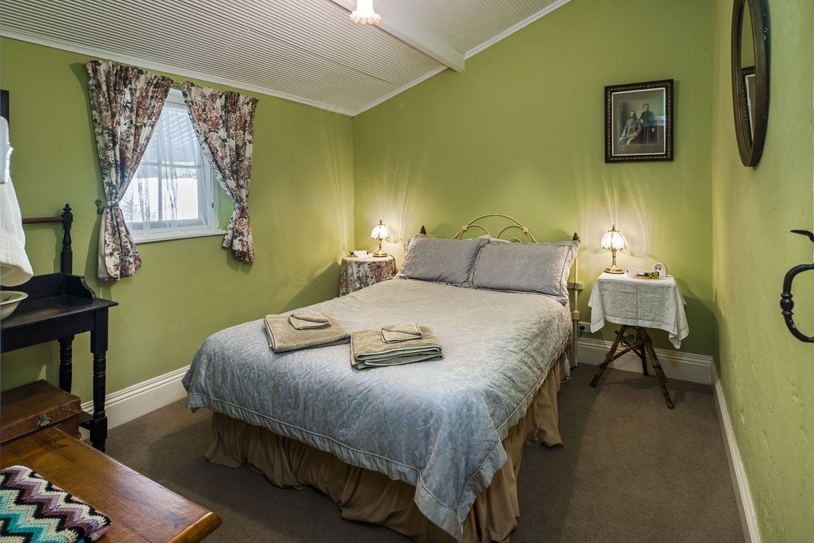 Cottage 10's queen bedroom, made up with folded towels and a lamp on the bedside table