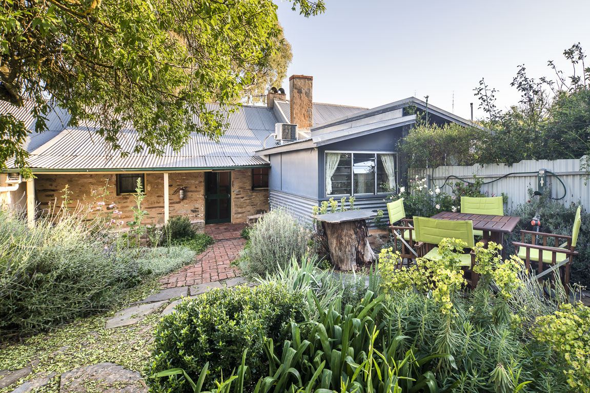 The private cottage garden with outdoor furniture on a paved path among shrubs