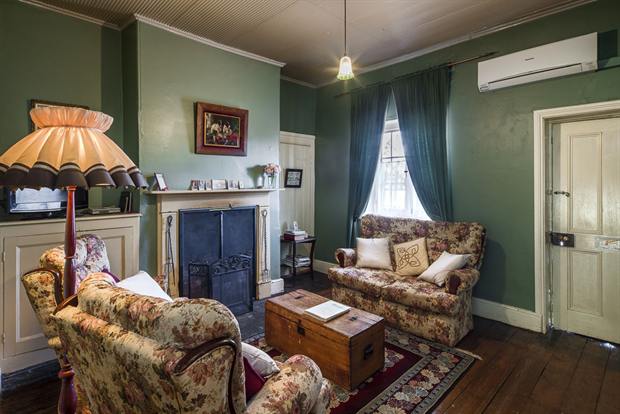 Cottage 8 — the cottage parlour with its open fireplace and armchairs