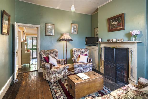 Cottage 8 — the cottage parlour with its open fireplace and armchairs